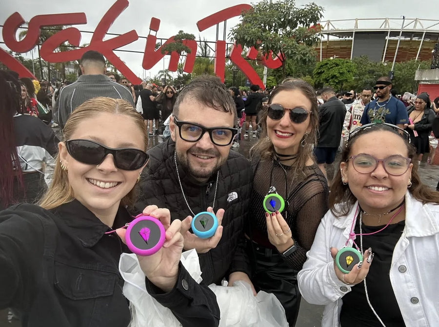 Four friends at Rock in Rio holding up their Totem Compasses